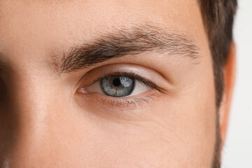 Man with blue eyes on white background, closeup