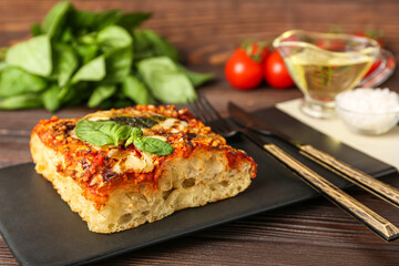 Board of tasty Italian pie with mozzarella and pesto sauce on wooden table, closeup