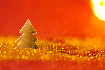 Christmas wallpaper in gold and red colors.Christmas tree mini in gold glitter on a on a red...