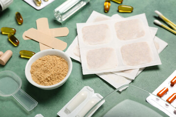 Mustard plasters with medicines on green background