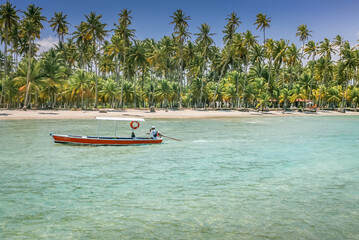Fototapeta na wymiar Carneiros idyllic beach with rustic boat at sunny day, in Northeastern Brazil