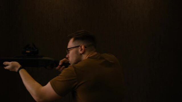 young man in glasses is going to hunt his prey. Hunting concept on brown background, Man looking for his prey, aim and walk away.