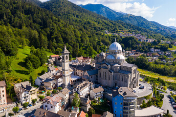 Fototapeta na wymiar General view of picturesque Re village in green Italian Alps in sunny summer day looking out over pilgrimage Sanctuary of Madonna del Sangue