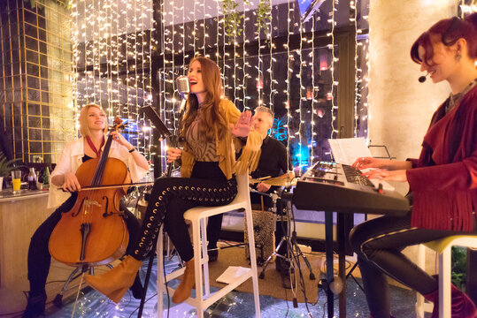 Musical Band Playing Music On The Small Concert Stage At Night In Restaurant