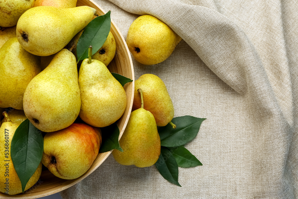 Wall mural bowl with ripe pears on fabric background, closeup - Wall murals