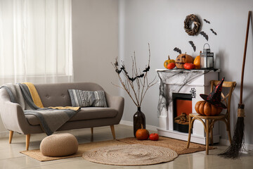 Interior of living room decorated for Halloween with fireplace, pumpkins and sofa