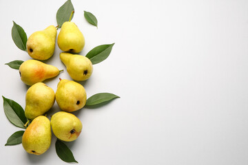 Ripe pears and green leaves on white background