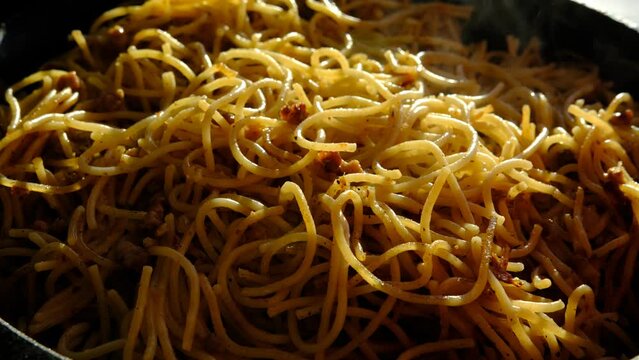 Hot spaghetti with steaming. Pasta with chopped pork steaming in the pan.