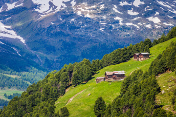 Snowcapped mountains in Stelvio national park with farms, Valfurva, Italian alps
