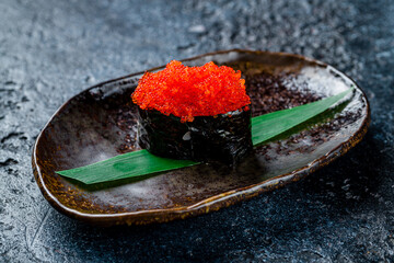 gunkan with masago caviar on dark stone table