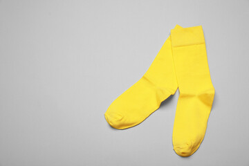 Yellow socks on grey background, flat lay. Space for text