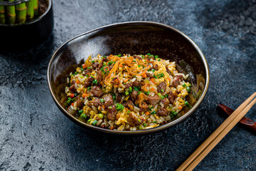 Fried rice with beef in Thai on dark stone table - 536861105