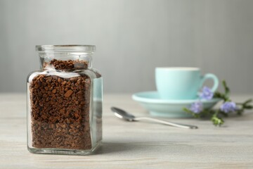 Jar of chicory granules on white wooden table, space for text
