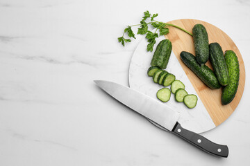 Fresh ripe cucumbers and parsley on white marble table, flat lay. Space for text