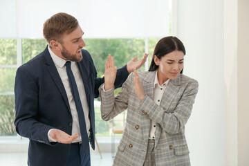 Man screaming at woman in office. Toxic work environment
