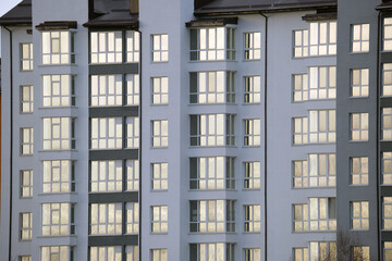 Architectural details of modern high apartment building facade with many windows and balconies
