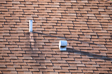 Closeup of house roof top covered with asphalt or bitumen shingles. Waterproofing of new building