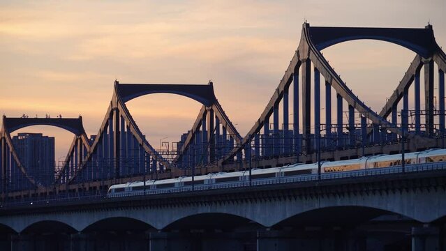 high speed train through steel bridge over river