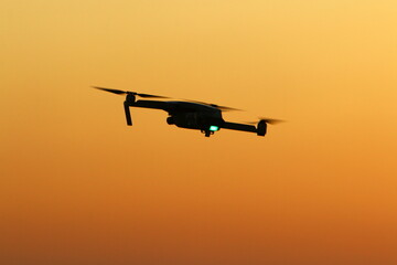 A quadrocopter with a photo camera flies over the sea.