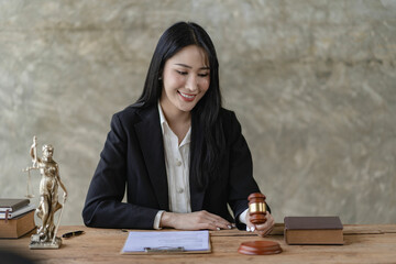Young Asian lawyer working in office with laptop concept of justice and law. lawyer work
About the contract documents of brass scales on a wooden table Legal services, advice, justice