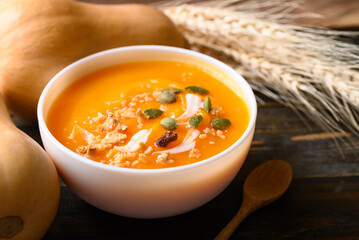 Butternut squash pumpkin soup in bowl on wooden background, Homemade food in autumn season