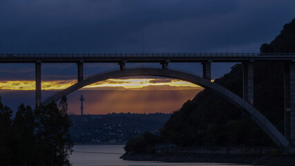 Fototapeta na wymiar Sunset landscape from the San Roque dam, looking to a large bridge and the last minutes of sunlight in Villa Carlos Paz , Cordoba 