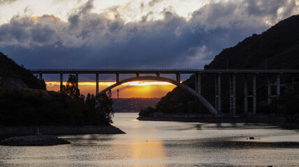 Sunset landscape from the San Roque dam, looking to a large bridge and the last minutes of ...