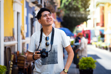 Summer outdoors smiling portrait of young lifestyle having fun in the city with photographer's travel camera.