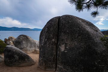 Big glacial boulders and rocks  on the lake Tahoe beach on a cloudy day in Sand Harbor in Nevada