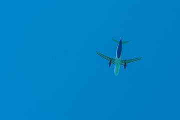 Aircraft in white blue coloring against the blue sky.