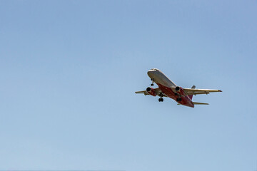 Aircraft in white red coloring against the blue sky.