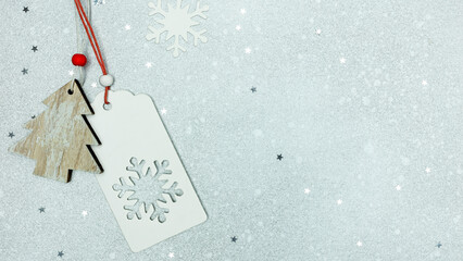 new year greeting card. gift tag with snowflakes and wooden fir on silver background with star...