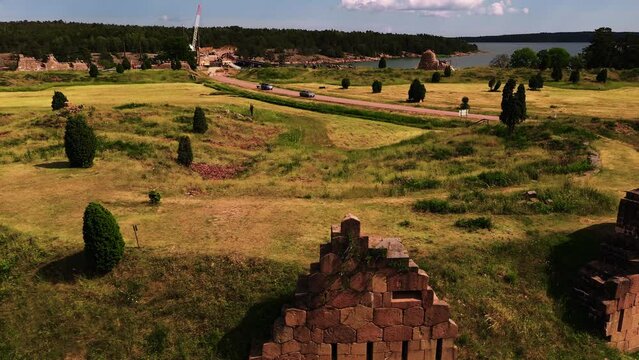 Aerial view of traffic on the road behind the Bomarsund castle walls, in Aland, Finland - low, tracking, drone shot