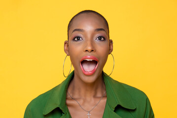 Headshot portrait of fashionable African American woman gasping in studio yellow color isolated...