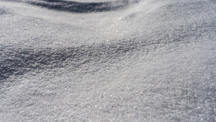 Pure untouched snow. Close-up. On the wavy surface, snowflakes sparkle in the sun. Full -screen. 
