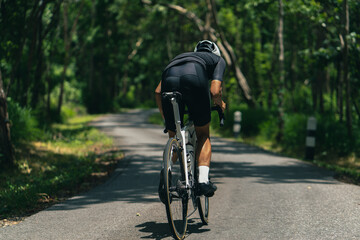 Fototapeta na wymiar Asian men are cycling road bike in the morning.He is on a forest road...