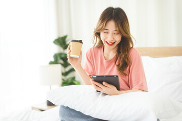 Asian woman with coffee using digital tablet for social message telemedicine and mental health or...