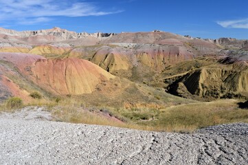 Badlands desert landscape valley with pink and yellow colored rocks.