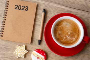 2023 GOAL with notebook, coffee cup, Christmas cookies and pen on wood table. Xmas, Happy New Year, Resolution, To do list, Strategy and Plan concept