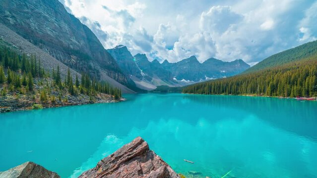 4K time-lapse UHD video of  beautiful view of an iconic famous place, Moraine Lake, a glacier lake located in Banff National Park,Alberta, Canada, in a colorful sunset cloudy summer autumn day. 