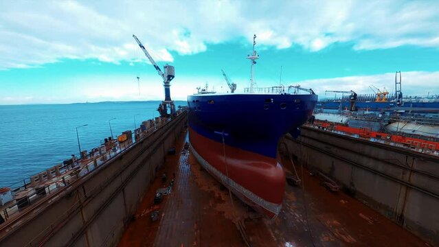 ship in dry dock. low aerial view. Shipbuilding, ship repair in dry dock. 4K