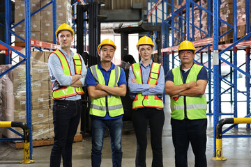 Group of warehouse workers with hardhats and reflective jackets standing and crossed arms with confident celebrate successful together or completed deal at retail warehouse logistics center