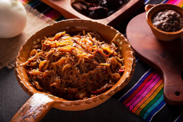Tinga de Res. Typical Mexican dish prepared mainly with shredded beef, onion and dried chilies. It is customary to serve it on corn tortilla tostadas or tacos.