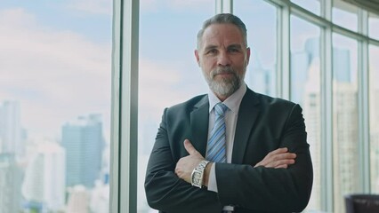 Portrait of a successful senior businessman wearing suit ,standing and crossing arms looking the camera at officer