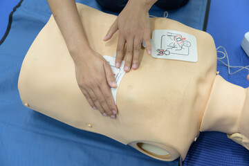 Demonstrating CPR (Cardiopulmonary resuscitation) training medical procedure on CPR doll by Automated External Defibrillator, AED technic in the class.First aid for safe life concept.