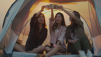 Friendship group of Asian young women having fun and enjoying drinking coffee in the tent, Camping trip. Screen capture from video