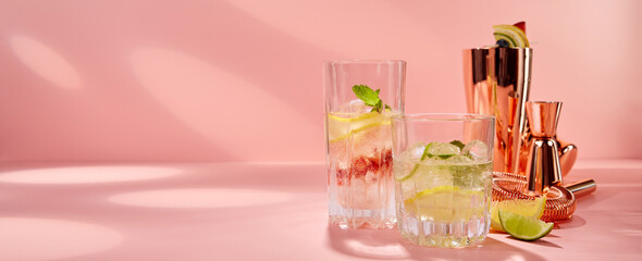 Glasses with mojito cocktail in pink studio