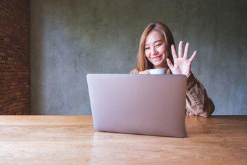 Portrait image of a beautiful young asian woman using laptop computer for video call, online meeting