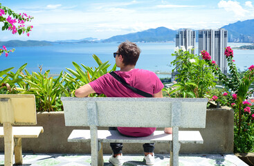 Young traveling man looking at landscape view from Chua Da Bao pagoda in Nha Trang Vietnam