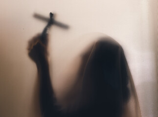 Shadowy figure with cross behind glass - horror background